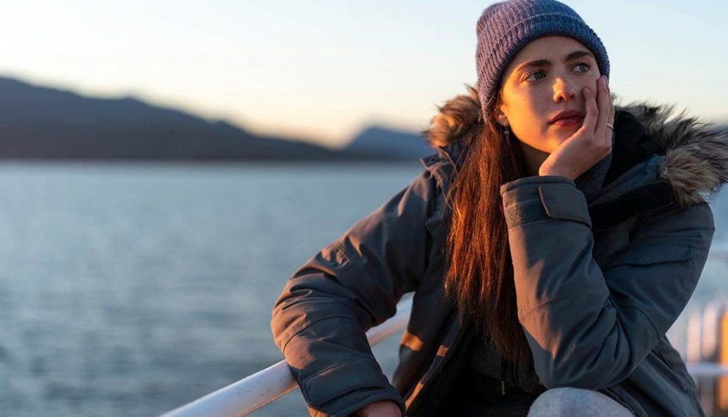 Margaret Qualley como Alex, de gorro, em uma balsa na minissérie Maid