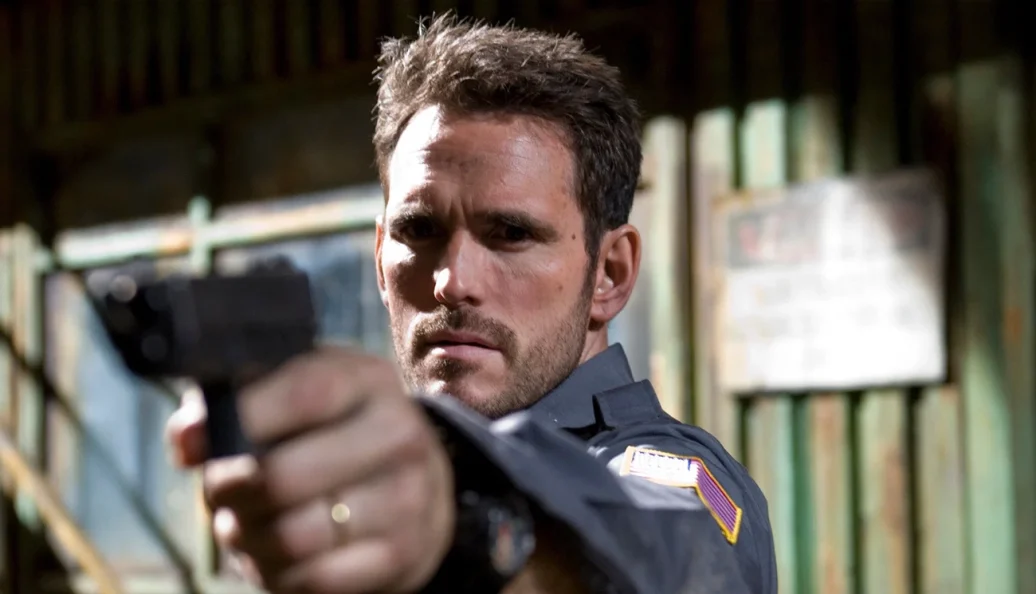 Matt Dillon segura uma arma em cena de Assalto ao Carro Blindado.