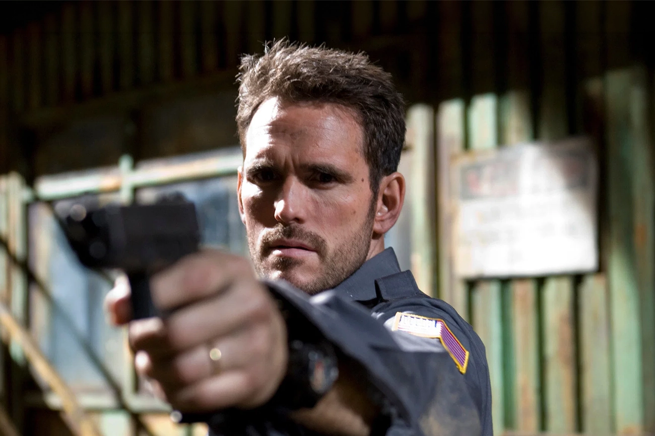 Matt Dillon segura uma arma em cena de Assalto ao Carro Blindado.