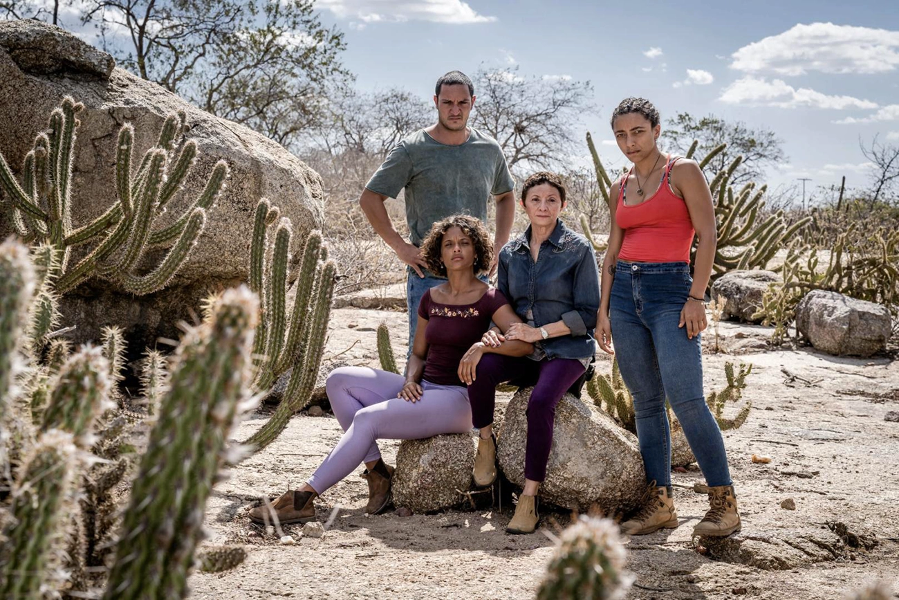 Quatro integrantes do elenco de Cangaço Novo entre cactos e rochas no sertão