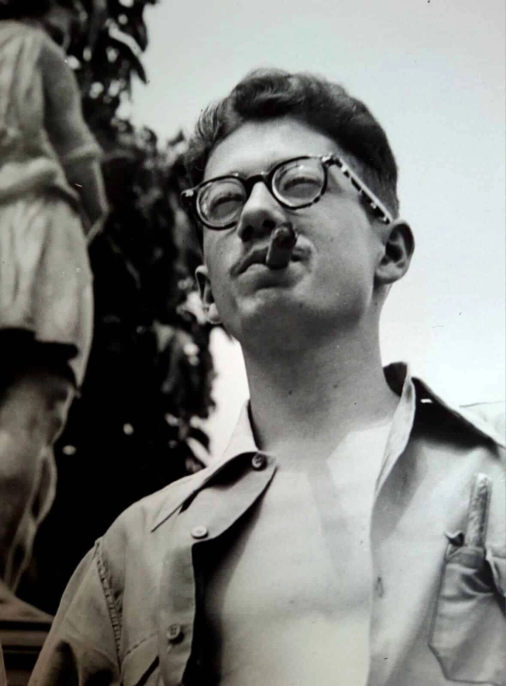 Dalton Trevisan de óculos e charuto, em fotografia em preto e branco.
