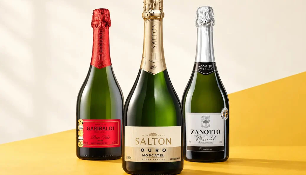 Garrafas de Garibaldi Pinot Noir Brut Rosé, Salton Ouro Moscatel e Zanotto Moscatel sobre fundo claro e amarelo.