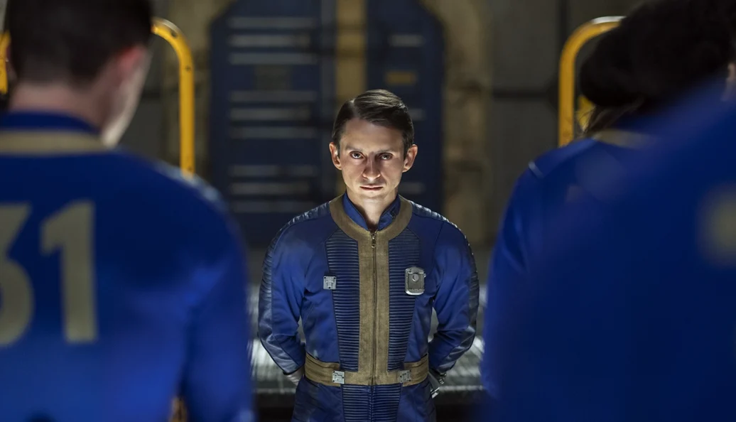 Personagens de Fallout com uniformes azuis dentro de um abrigo.