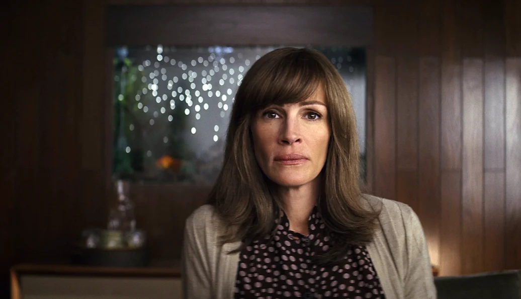 Mulher de cabelos castanhos em um escritório na série Homecoming.