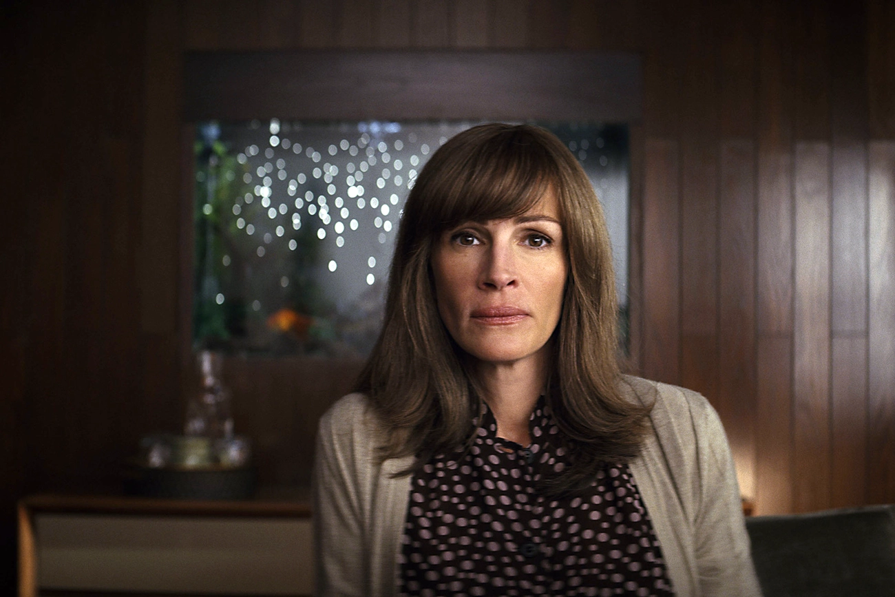 Mulher de cabelos castanhos em um escritório na série Homecoming.