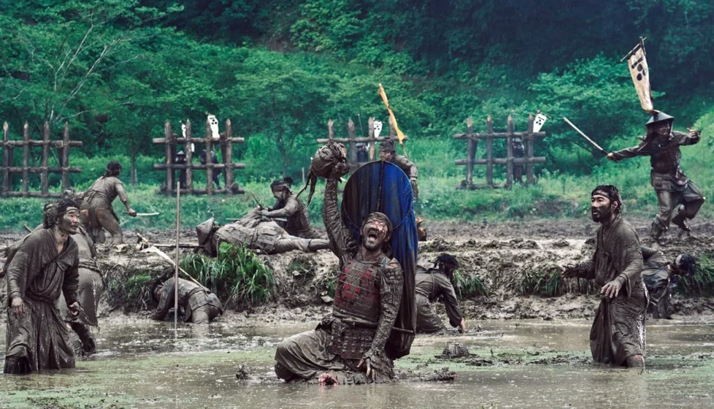 Cena de batalha de Kubi, com guerreiros em um campo alagado.