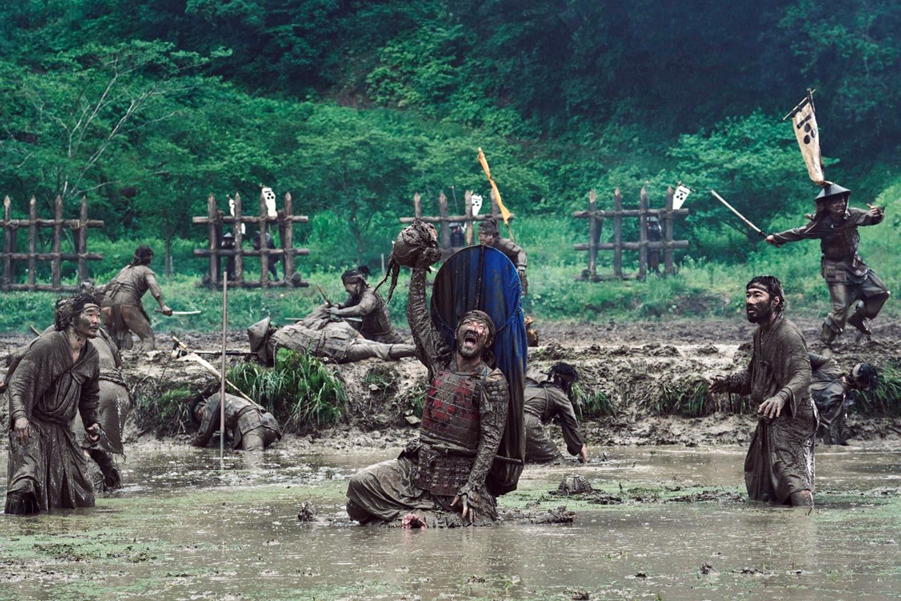 Cena de batalha de Kubi, com guerreiros em um campo alagado.