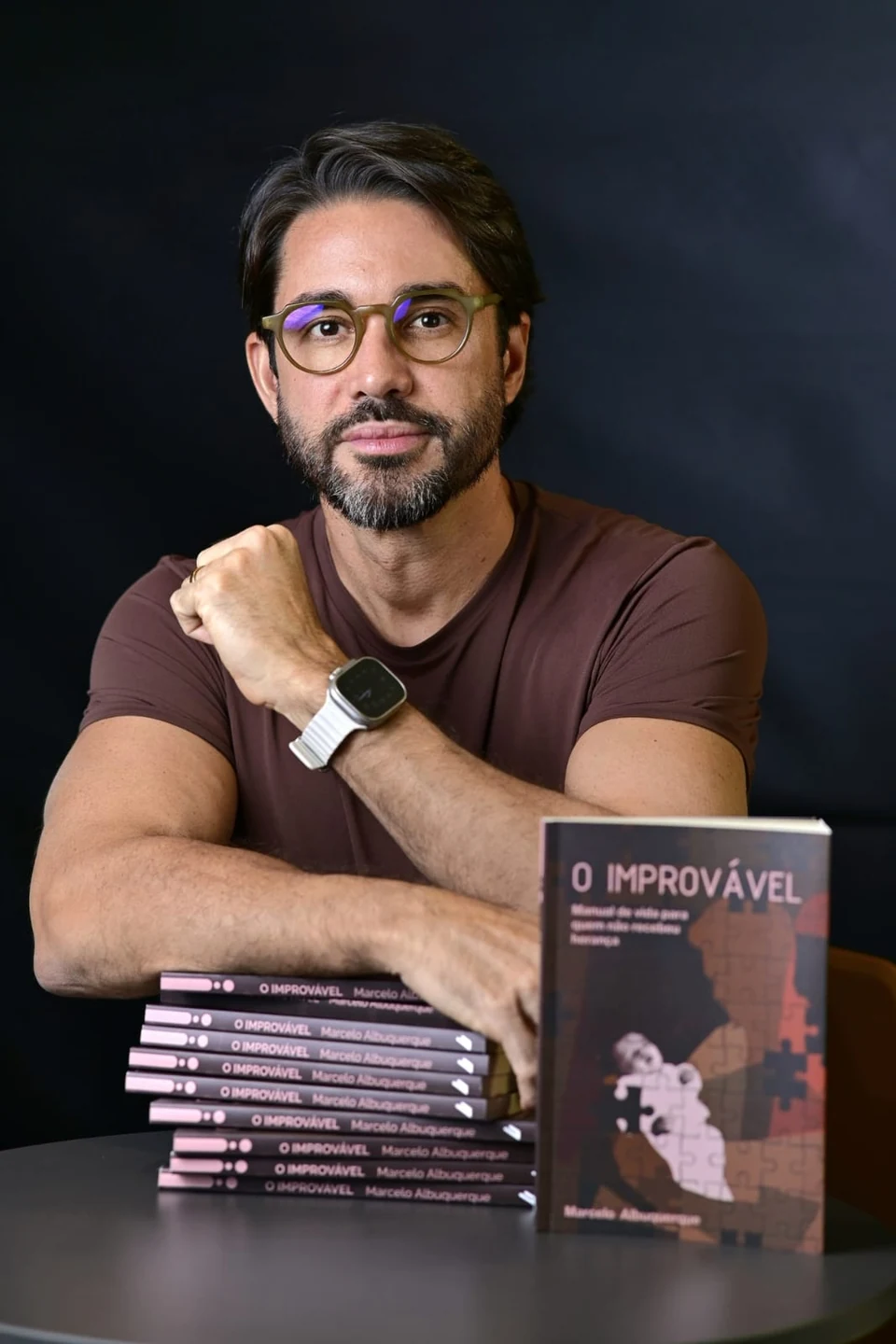 Marcelo Albuquerque ao lado de exemplares de O Improvável, seu livro de estreia.