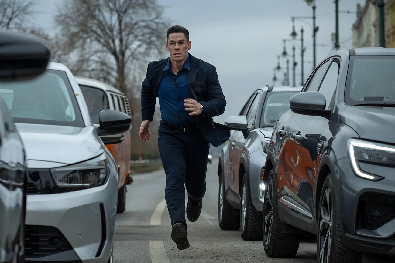 John Cena corre entre carros em cena de Matchbox — O Filme.