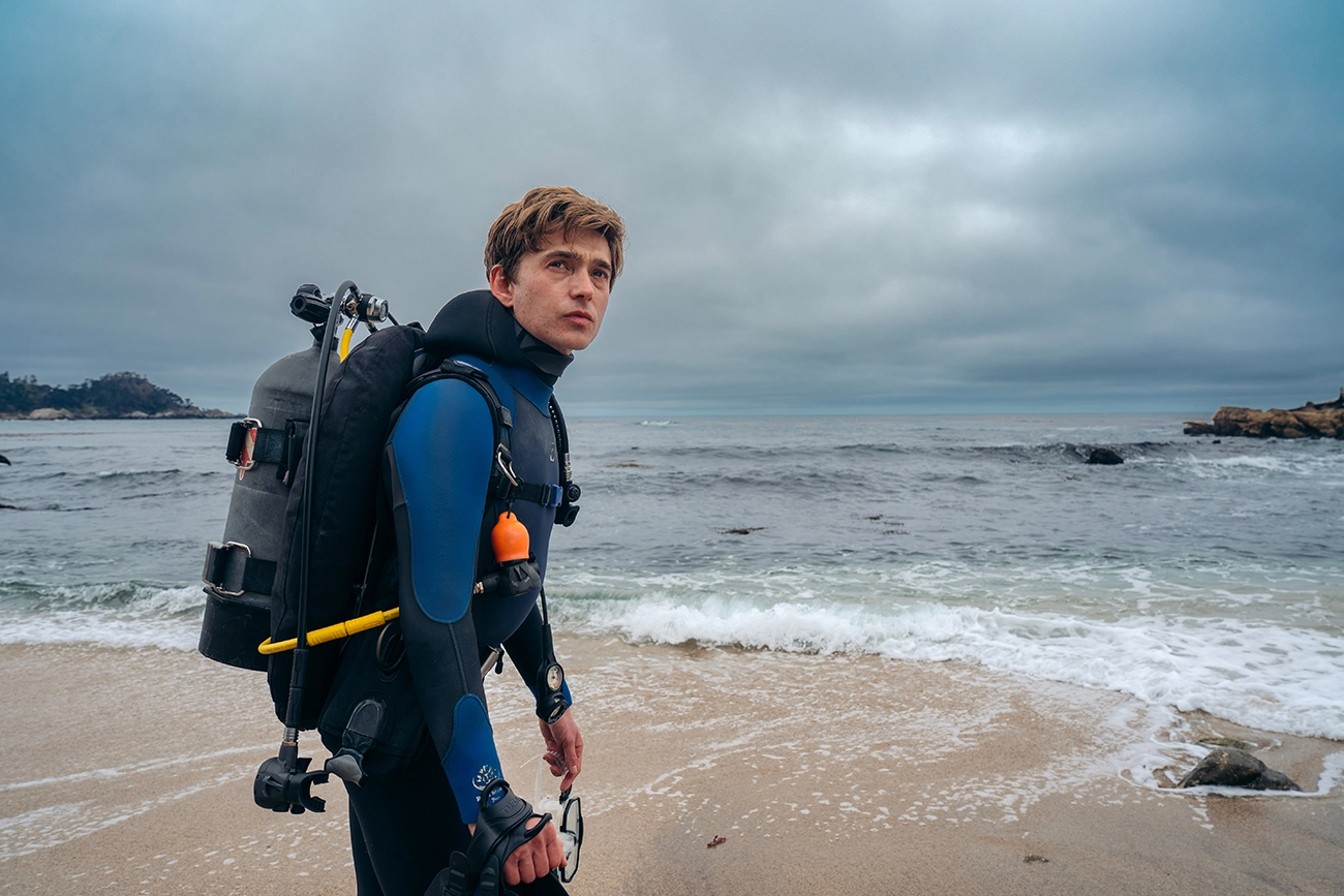 Austin Abrams como Jay Gardiner, com equipamento de mergulho, em Dentro da Baleia (2026)