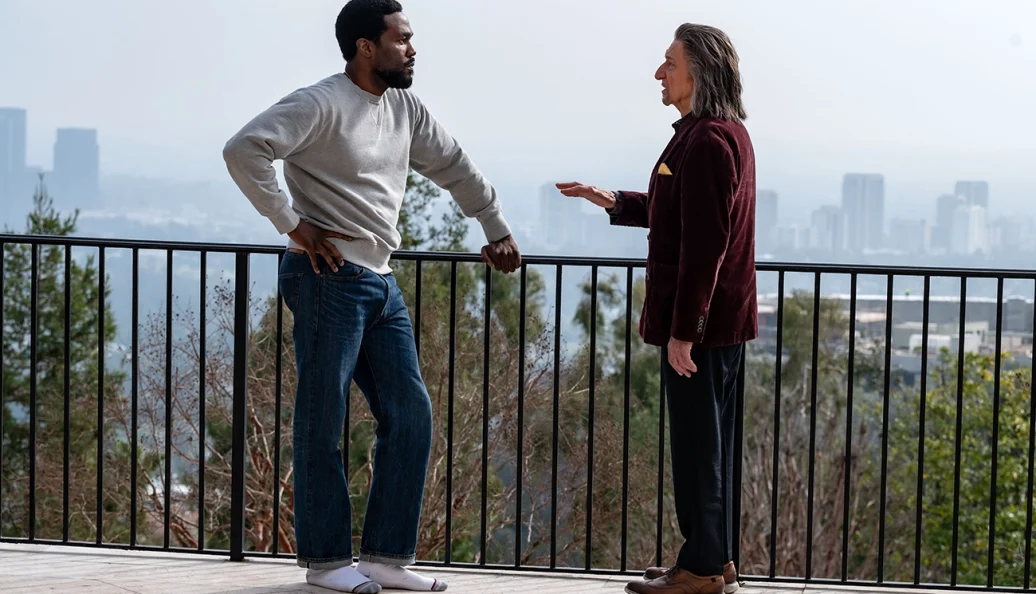 Yahya Abdul-Mateen II e Ben Kingsley conversam em uma varanda em Magnum.